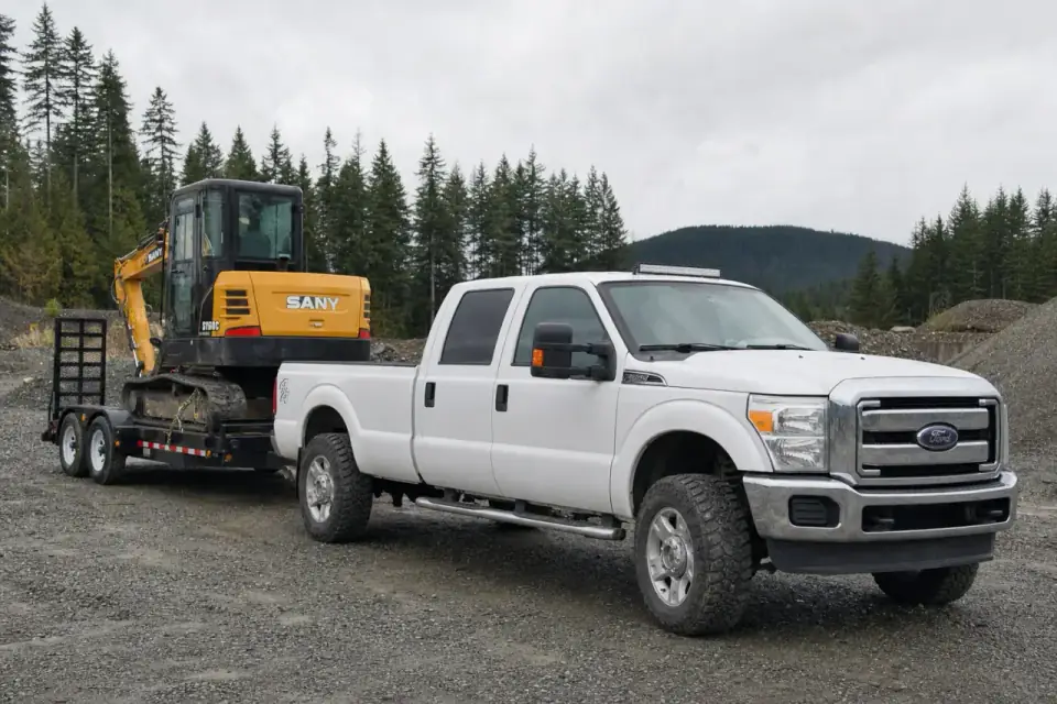 Yellow excavator secured on a trailer for transport
